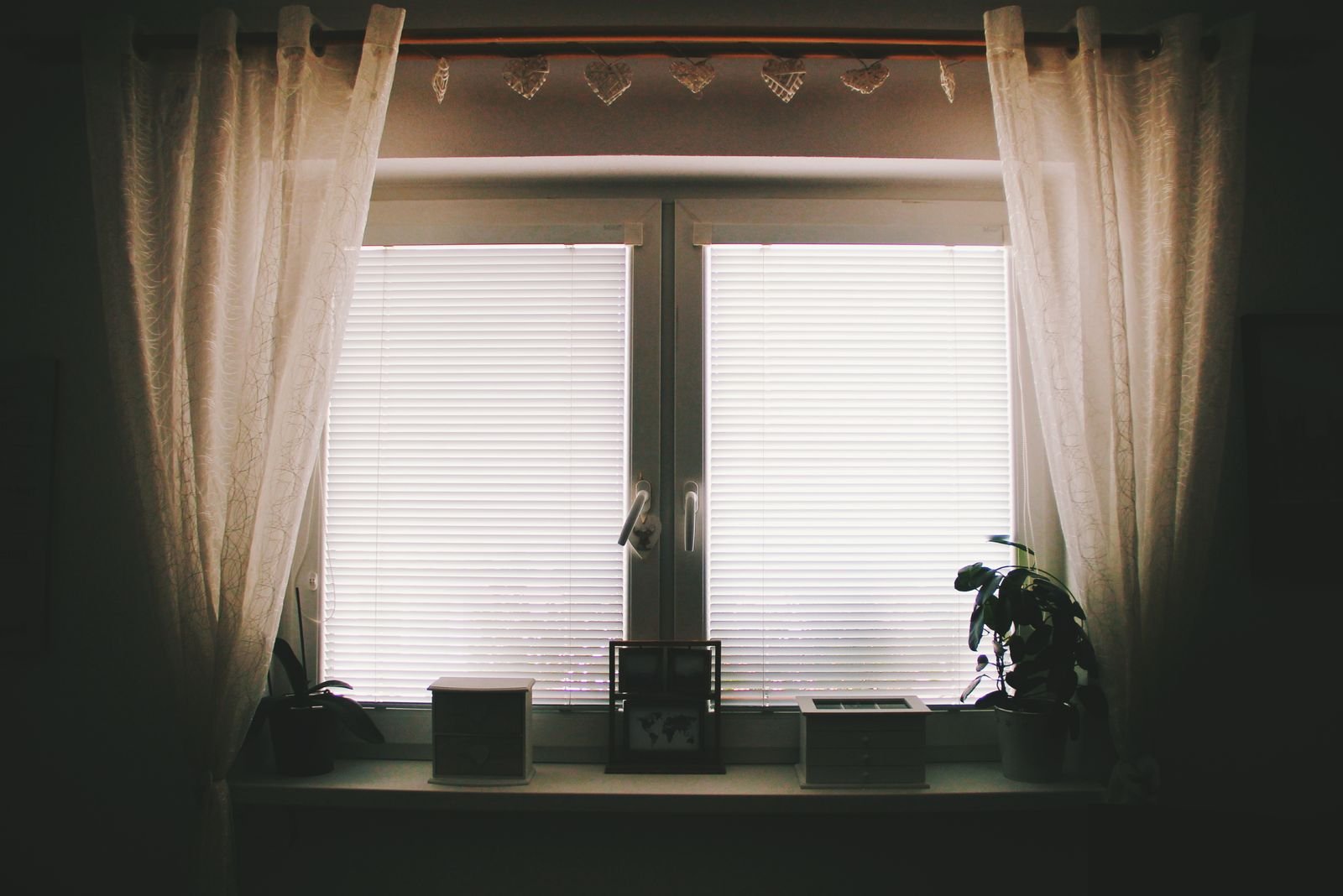 sheer curtains open at a home window letting in daylight