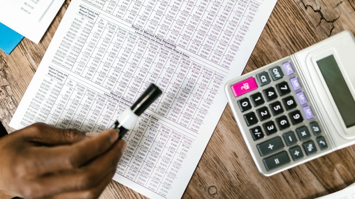 Working out debt snowball and debt avalanche numbers with a calculator and notebook