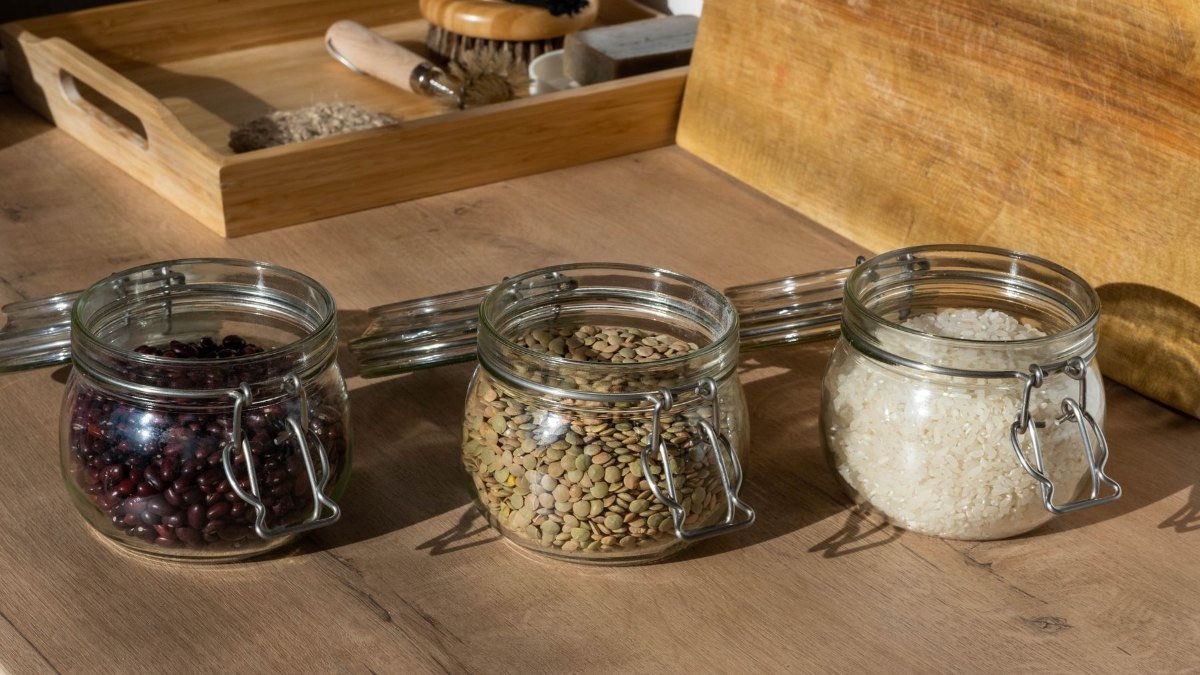 jars of beans lentils and rice set out on a wooden table