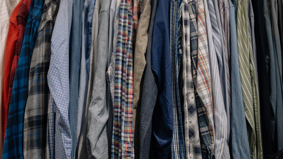 button-up shirts hanging on a rack at a secondhand store